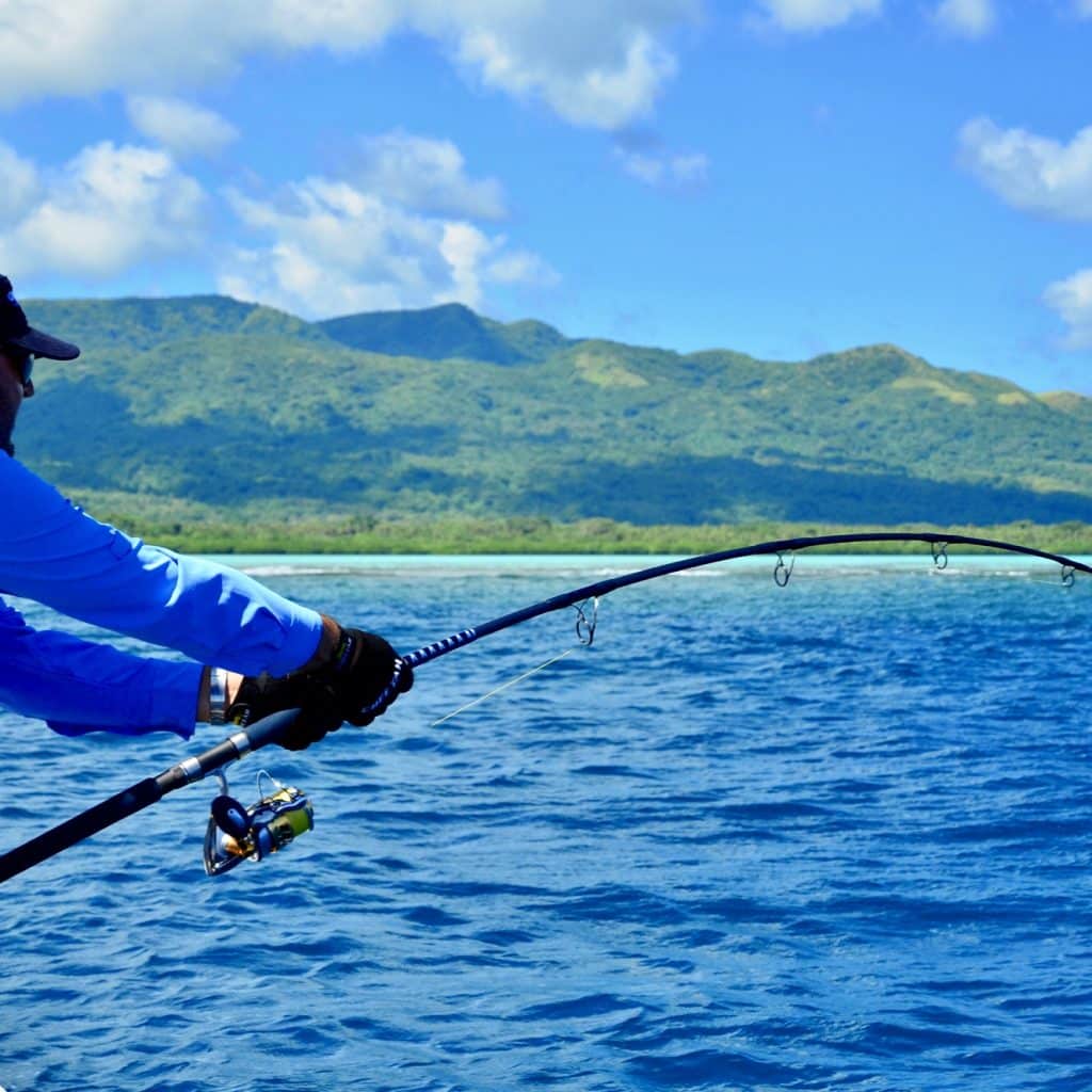 Angler working a popper for giant trevally along an Efate reef edge in Vanuatu.