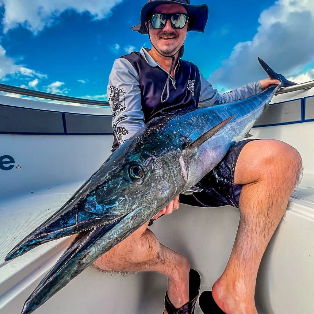 Angler holding a wahoo aboard EdgeWater centre console in Vanuatu.