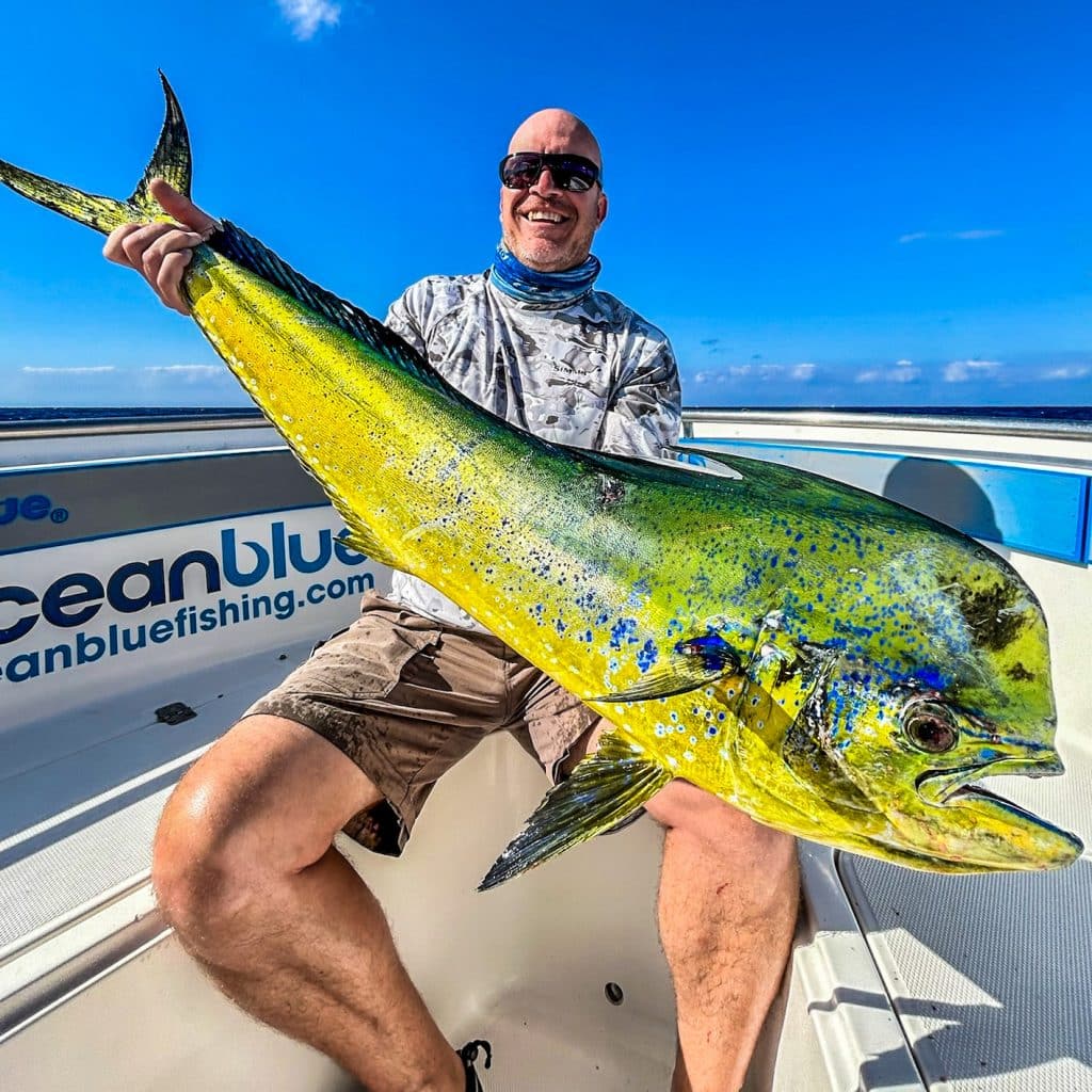 Angler with a mahi‑mahi aboard Ocean Blue in Vanuatu.