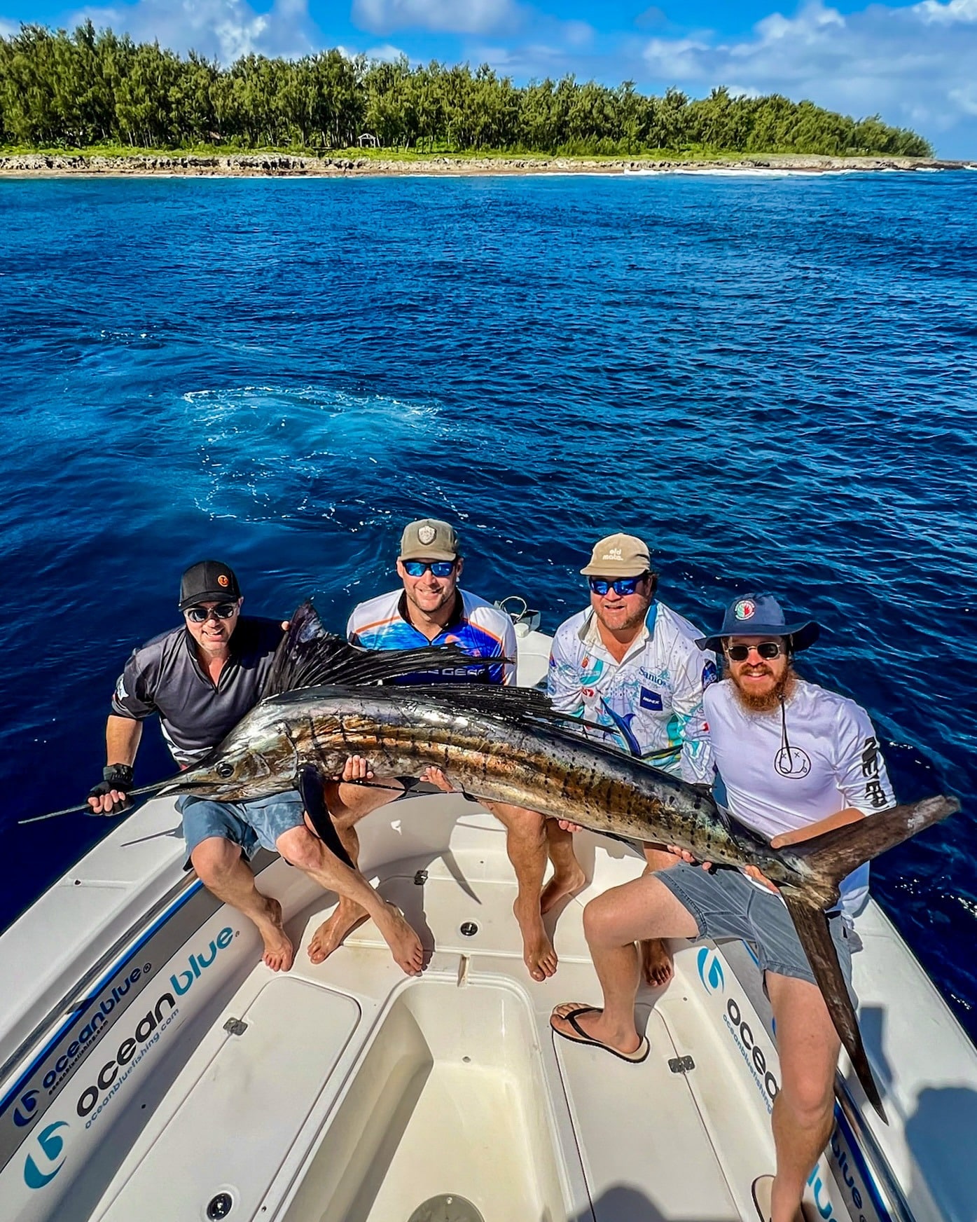 Four anglers on a fishing boat in Vanuatu holding a large Sailfish caught on a bluewater sport fishing trip with Ocean Blue Fishing Adventures.