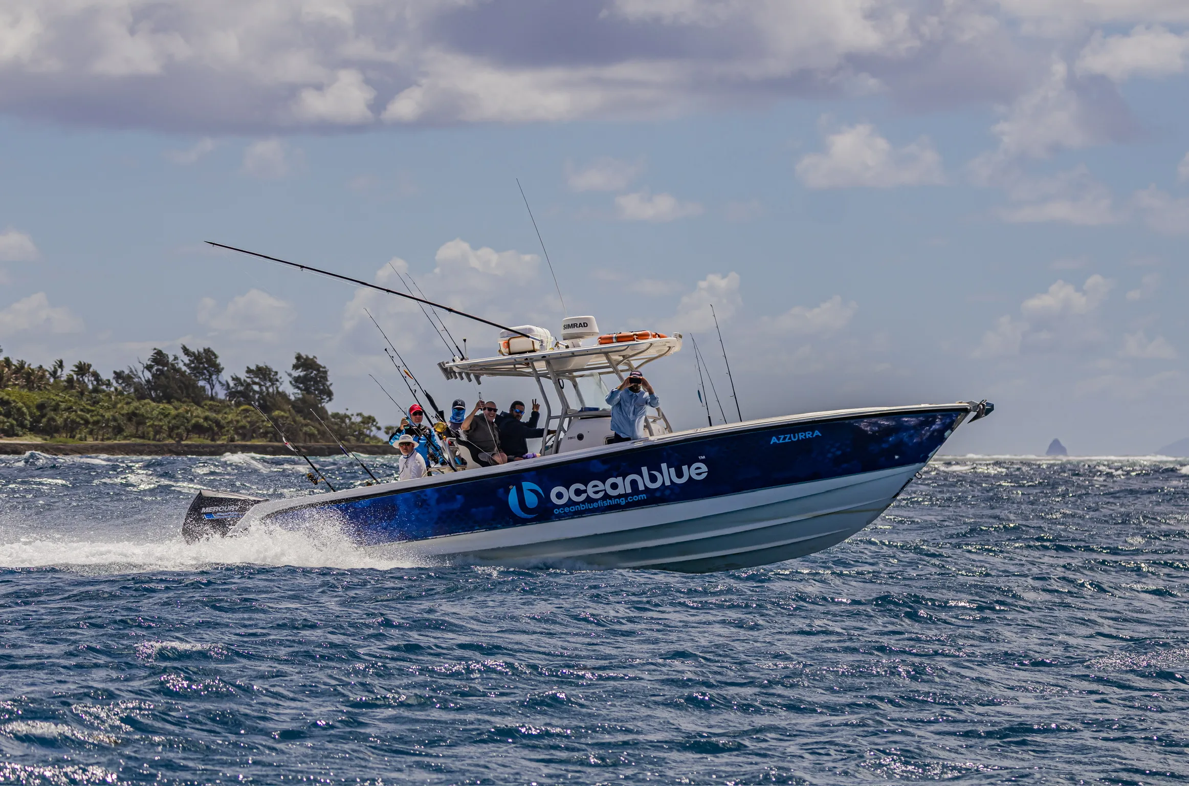 Ocean Blue Fishing Adventures centre-console charter boat “Azzurra” cruising fast on choppy blue water in Vanuatu, with anglers onboard and rods set.