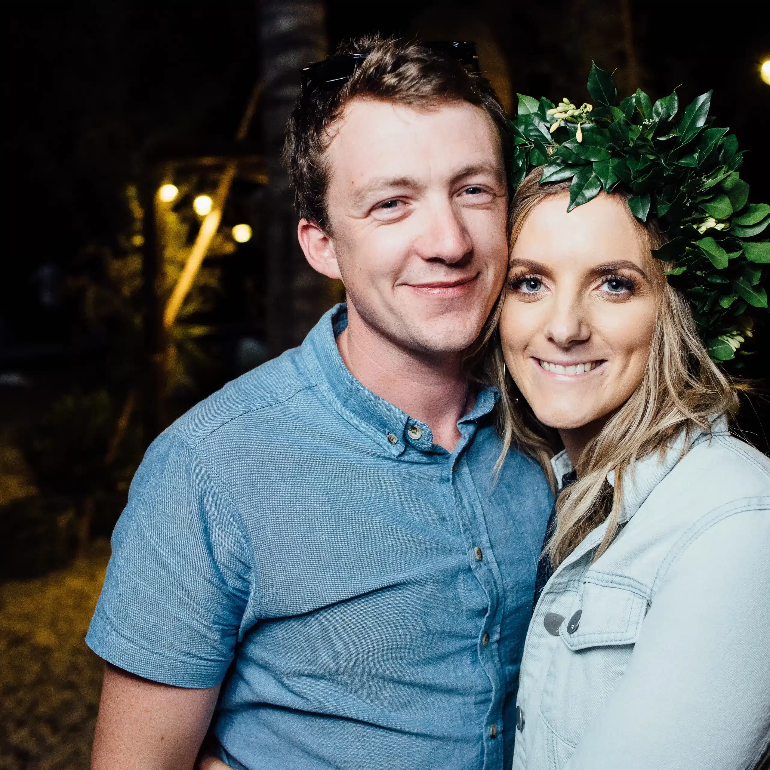 Couple smiling together during a romantic getaway in Vanuatu, with the woman wearing a leafy flower crown.