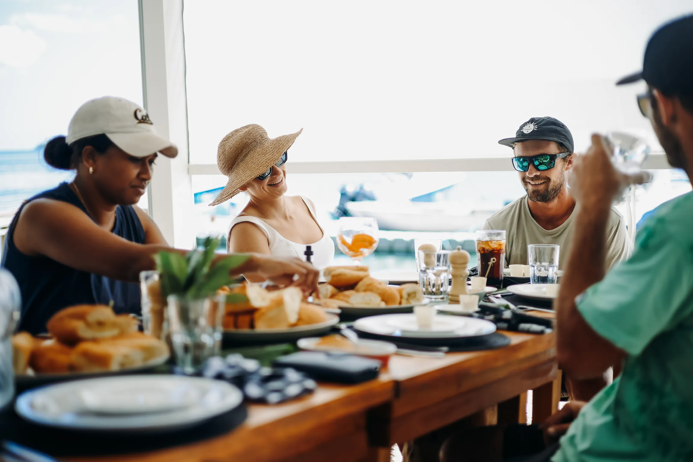 Guests enjoying a relaxed meal together at Trees and Fishes in Vanuatu, seated around a table with drinks and shared dishes.