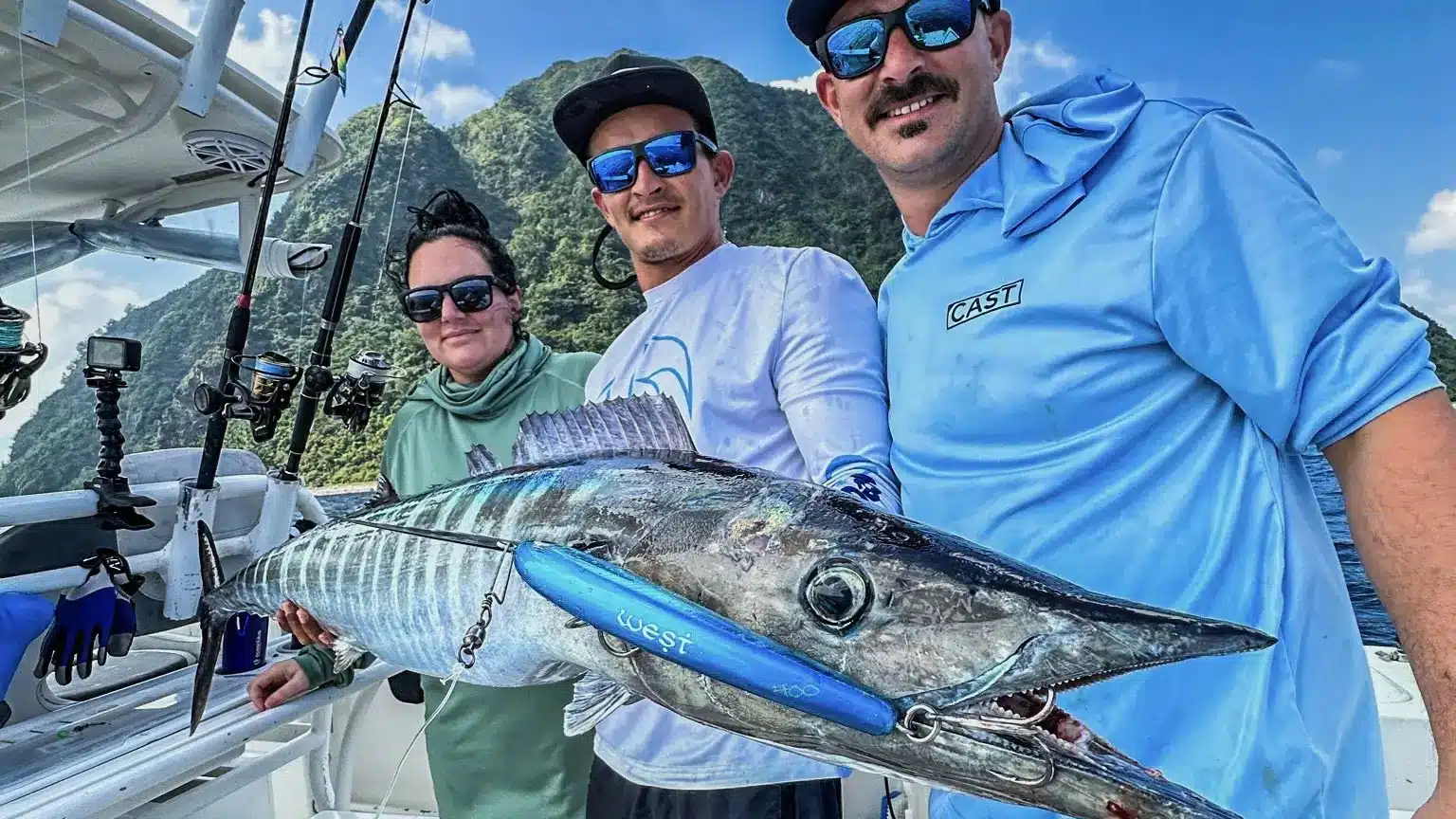 Couple in Vanuatu holding a Wahoo, enjoying a Couples Fishing Adventure with Ocean Blue Fishing against a stunning ocean backdrop