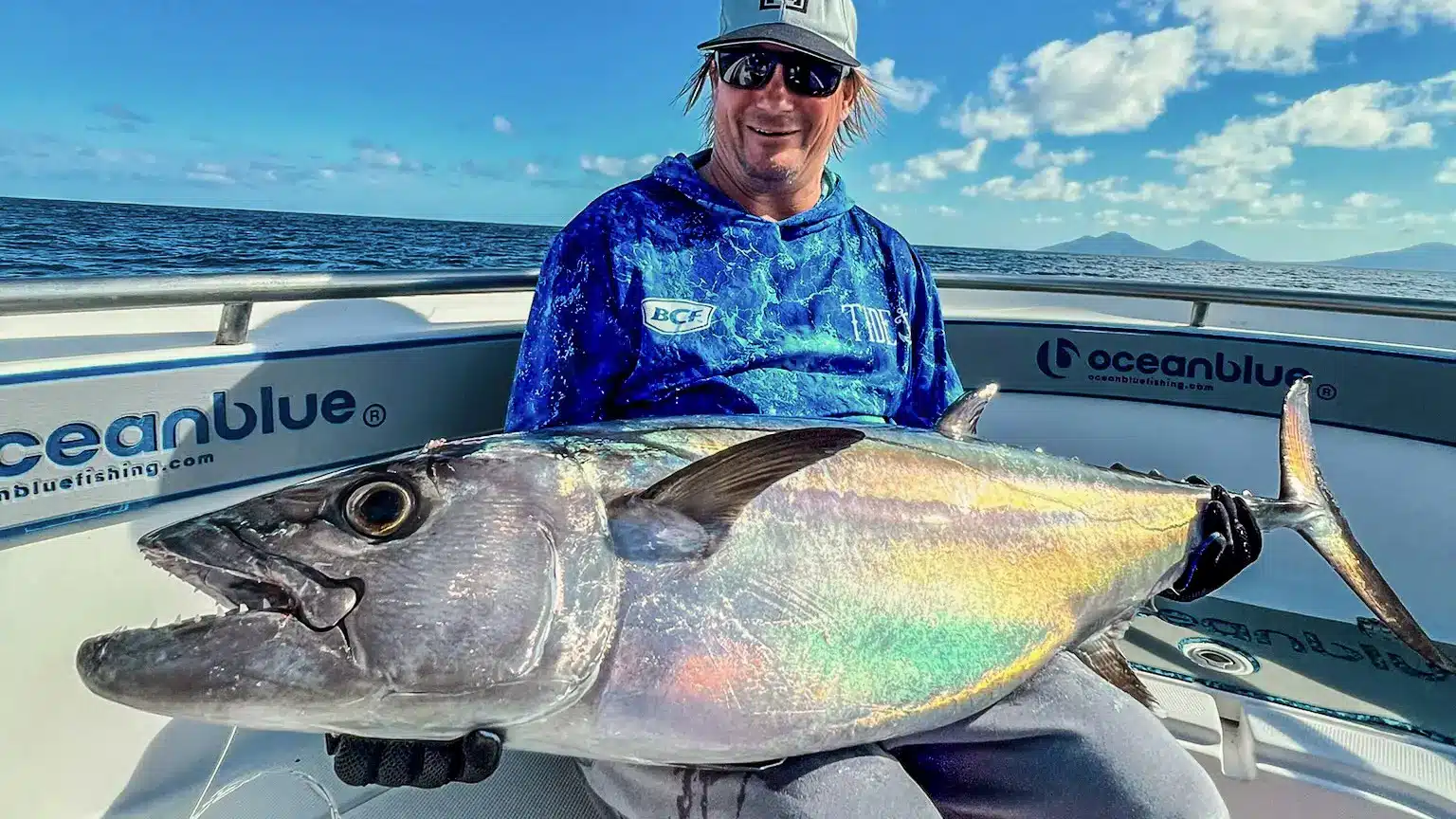 Angler holding a massive dogtooth tuna on a boat in Vanuatu, Ocean Blue Fishing Adventures